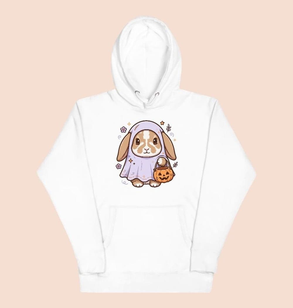 A friendly Halloween illustration of the pet in a loose ghost costume with their face and ears visible, holding a tiny pumpkin bucket, on a hoodie (example made with AI)