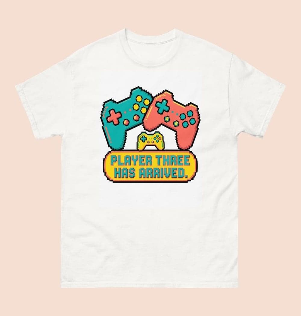 A cheerful original game-inspired emblem with two large controllers and one tiny controller between them, on a t-shirt (example made with AI)