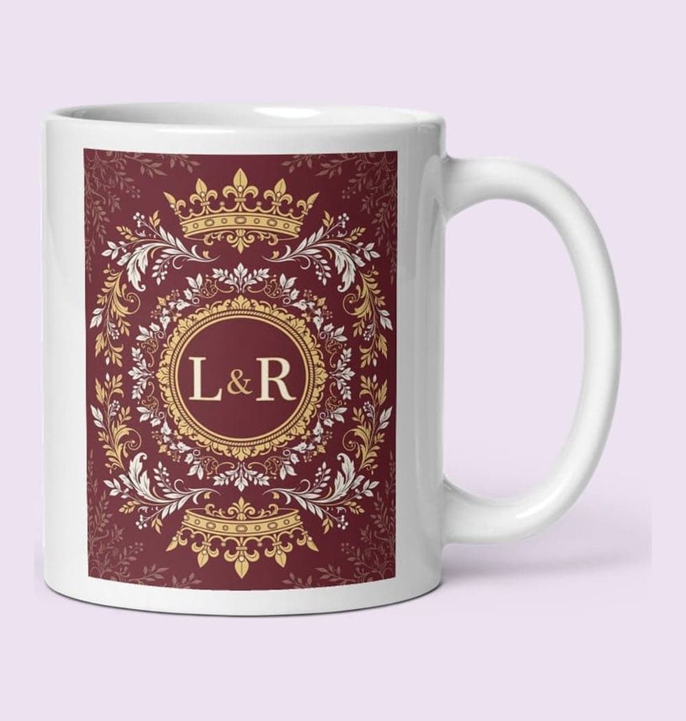 An original, rotationally symmetric fantasy crest with two mirrored crowns, decorative foliage, and the initials at the center, on a mug (example made with AI)