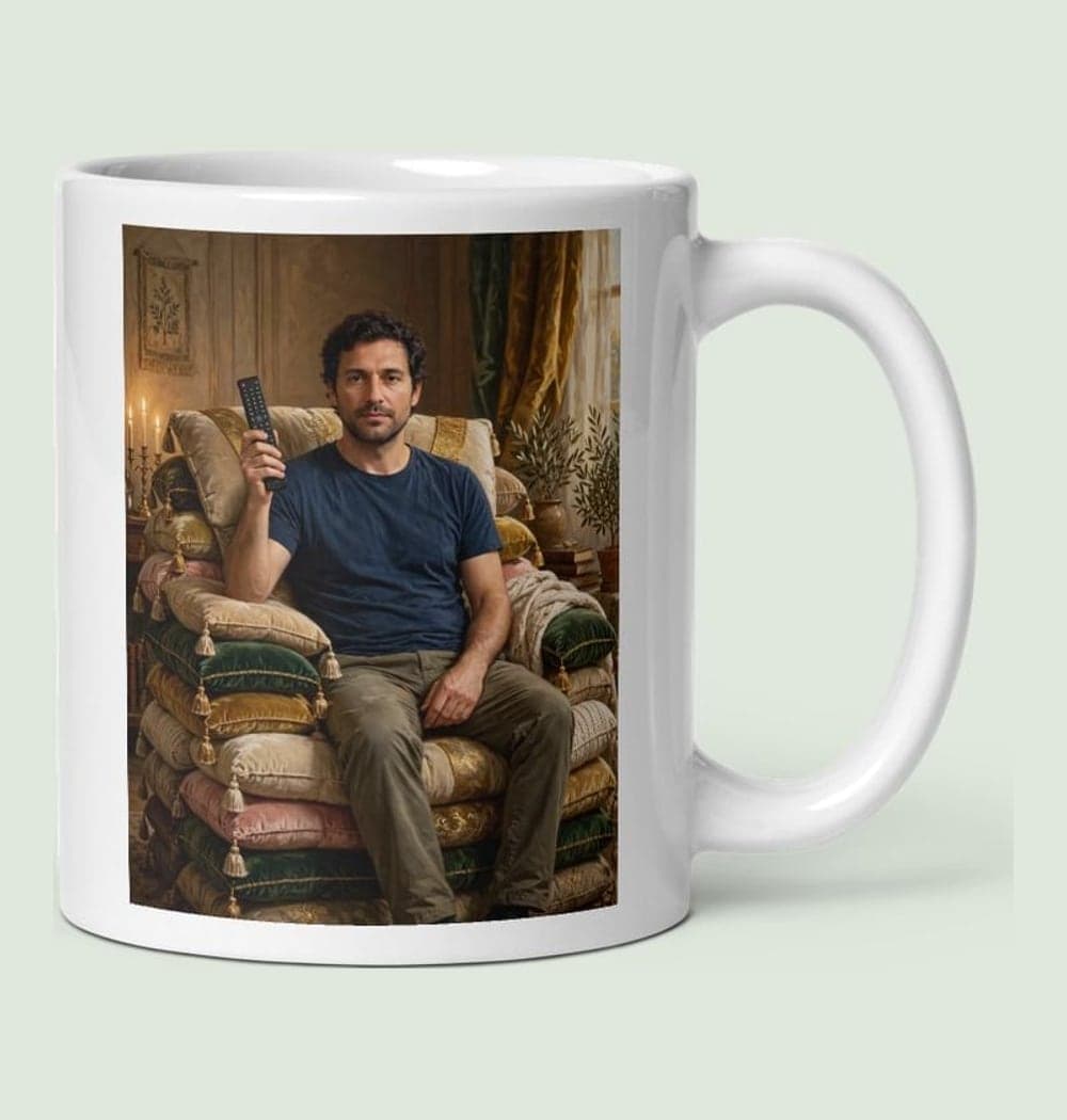 A solemn ruler seated on a throne of sofa cushions, holding a television remote like a scepter, on a mug (example made with AI)