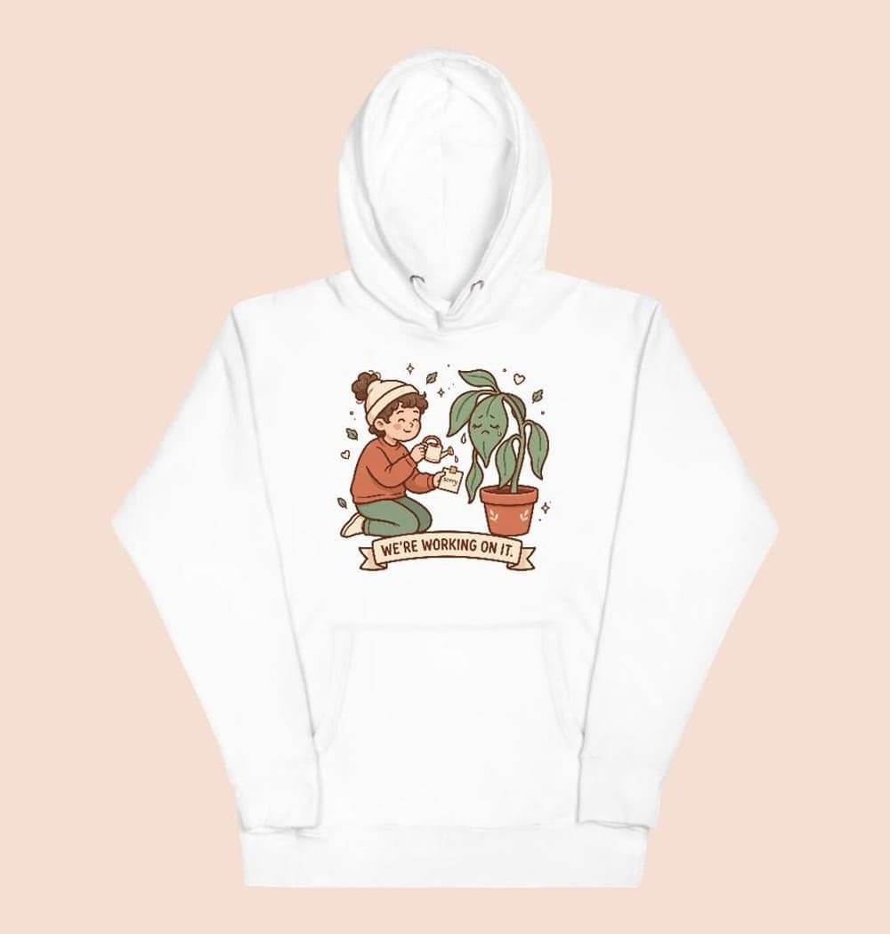 A gentle cartoon of a person offering a tiny watering can and an apology note to a melodramatically drooping houseplant, on a hoodie (example made with AI)