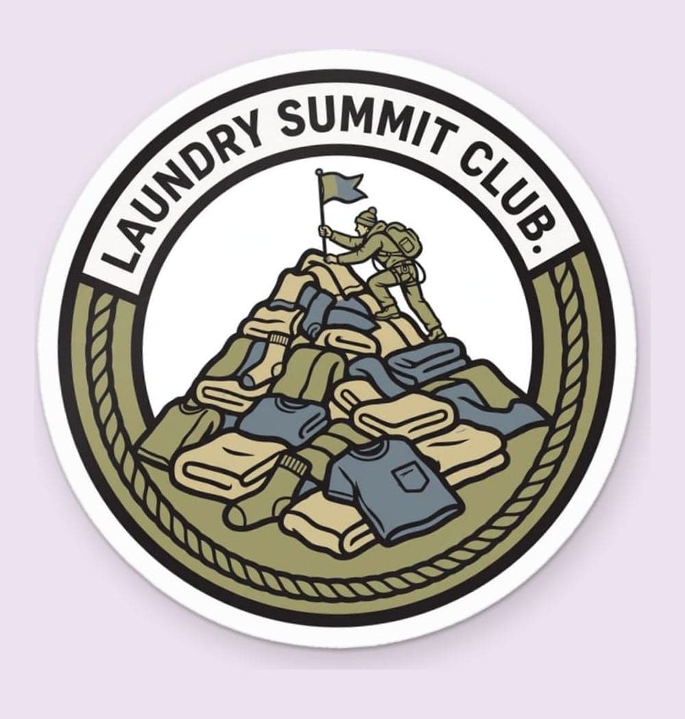 An original sports-style crest featuring a climber planting a flag atop a mountain of laundry, as a sticker (example made with AI)