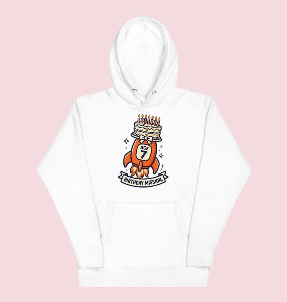 An original cartoon rocket carrying a birthday cake with the supplied age displayed clearly on its side, on a hoodie (example made with AI)