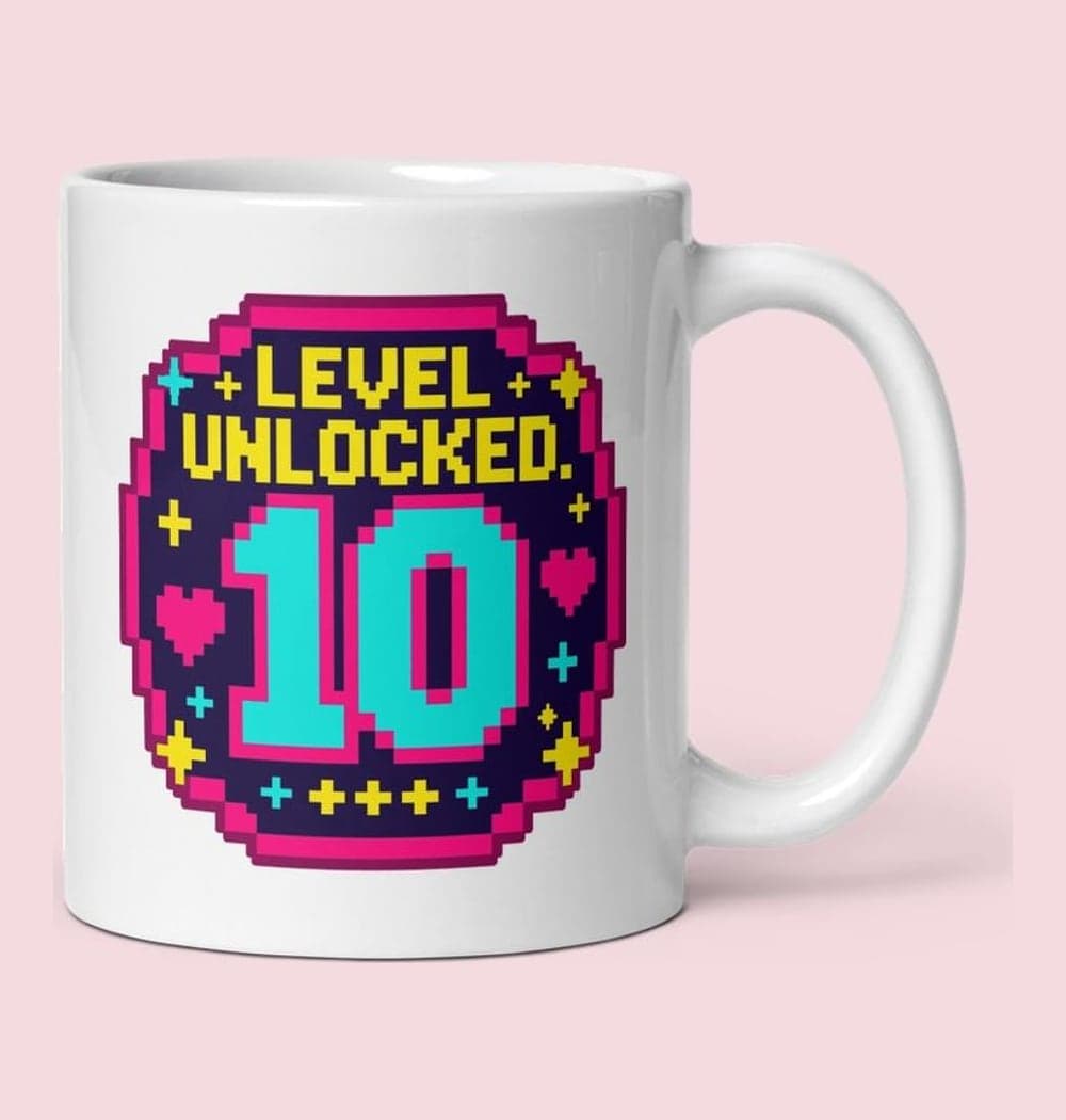 An original arcade-style birthday emblem with the supplied age as a large central number and the words “LEVEL UNLOCKED.” Add small stars, hearts, and geometric sparkles, on a mug (example made with AI)
